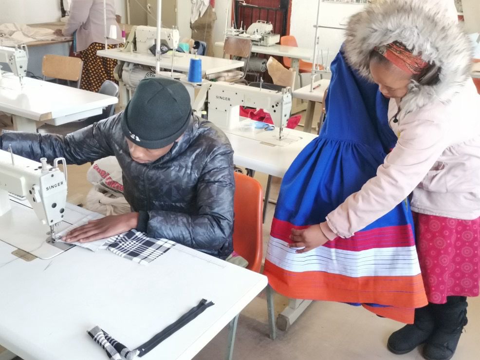 Sewing classroom — students at Singer machines working on fabric