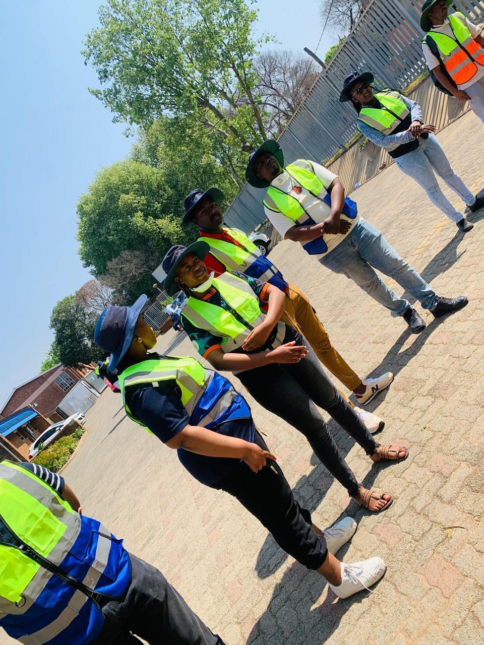 Learners in hi-vis vests outdoors — a candid moment